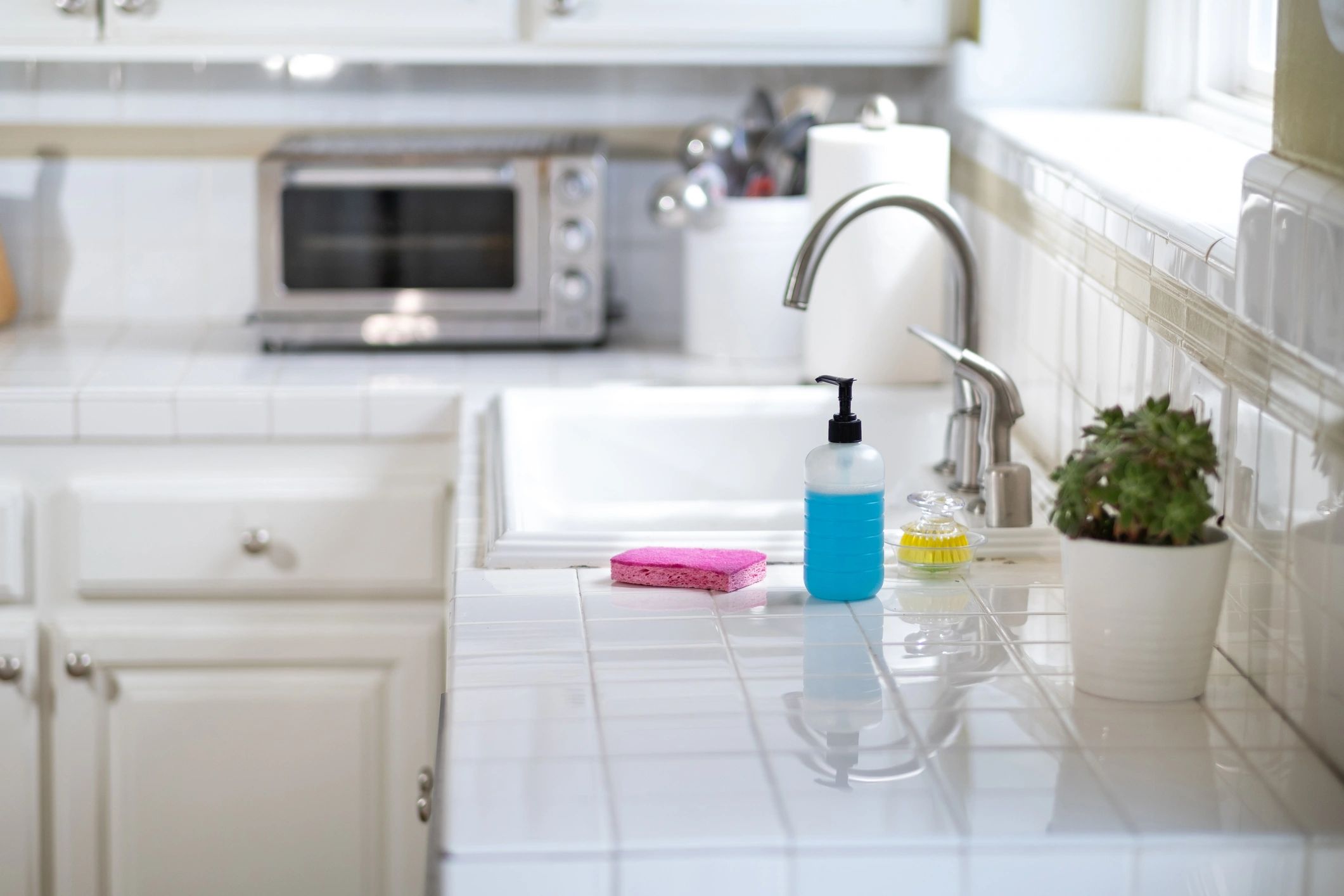 Kitchen sink and cleaning supplies representing dishwash and home care formulas