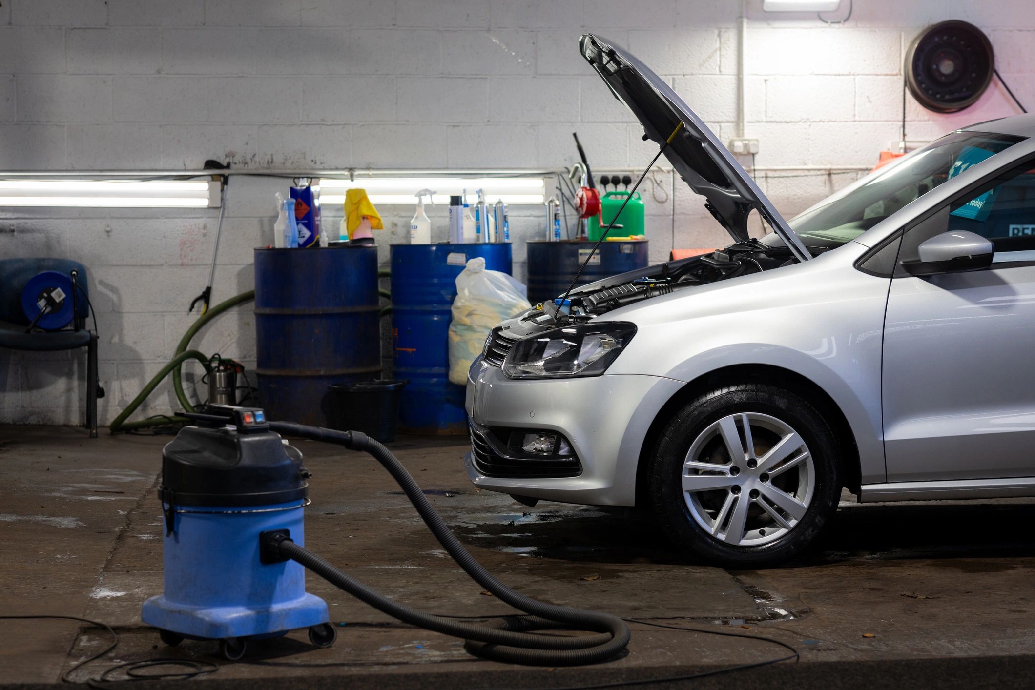 Car in a garage with detailing and service equipment